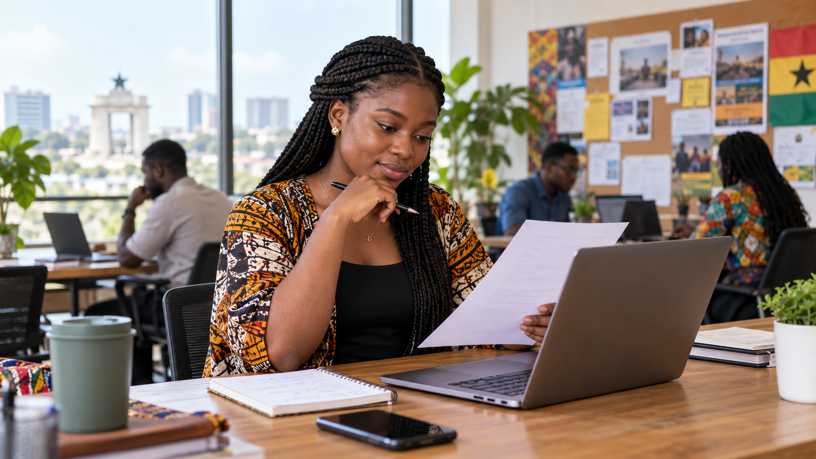 A Ghanaian job seeker reviews an application at a laptop in an Accra workspace